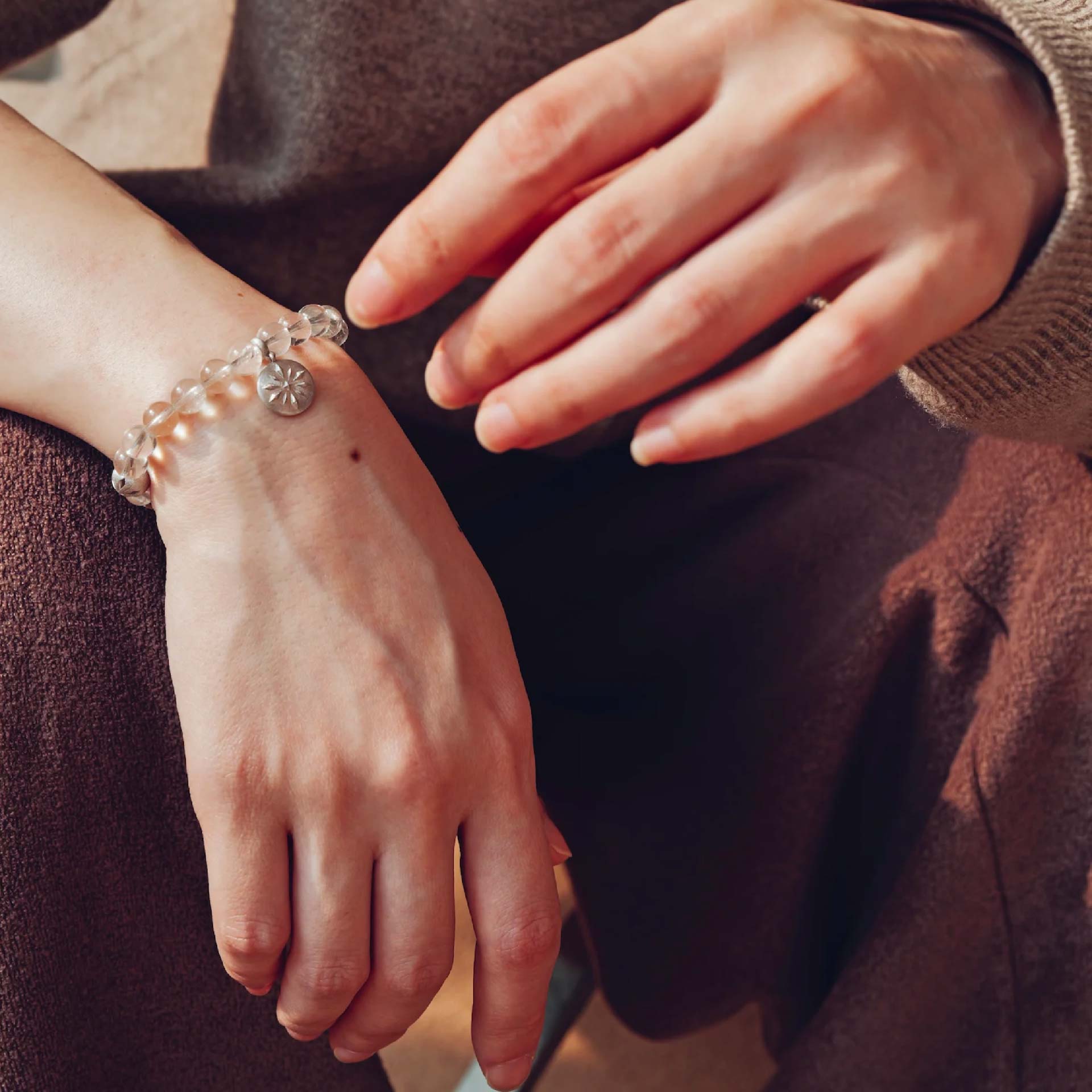 Person wearing a crystal bracelet on their wrist