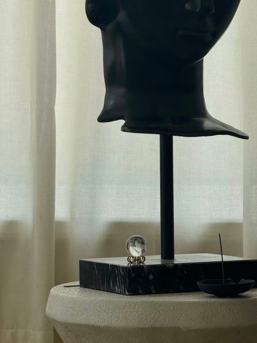 Crystal sphere displayed beside a meditating sculpture
