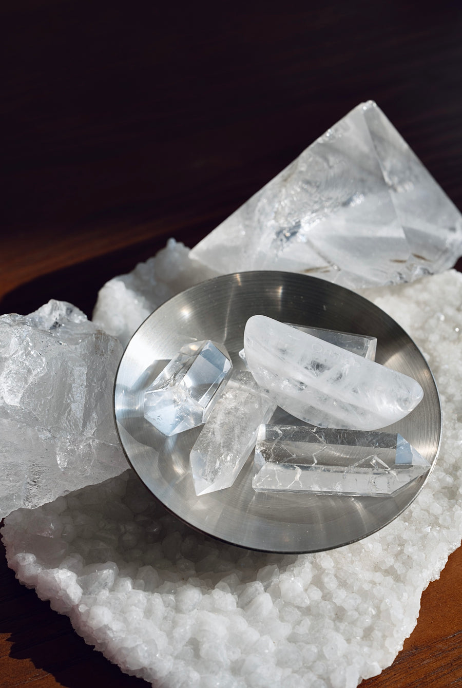 Clear quartz sphere and point displayed on a crystal cluster
