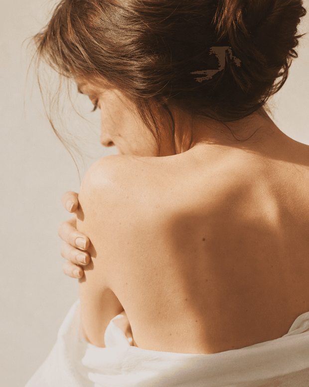 Woman gently embracing herself in warm natural light