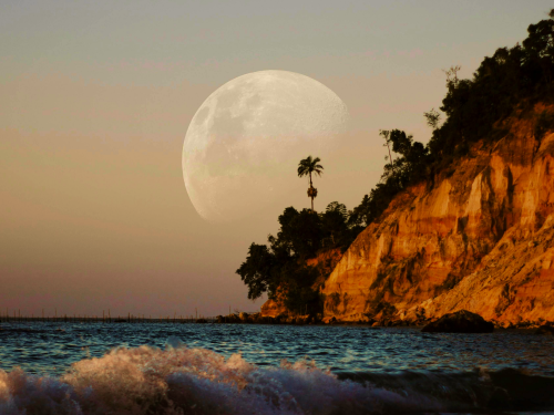 Full moon rising over a rocky seaside cliff