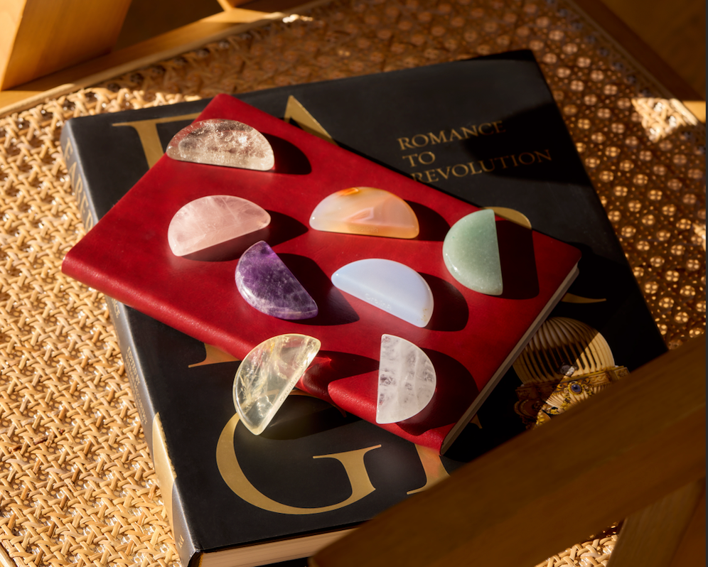 Seven ritual stones arranged on books and red fabric