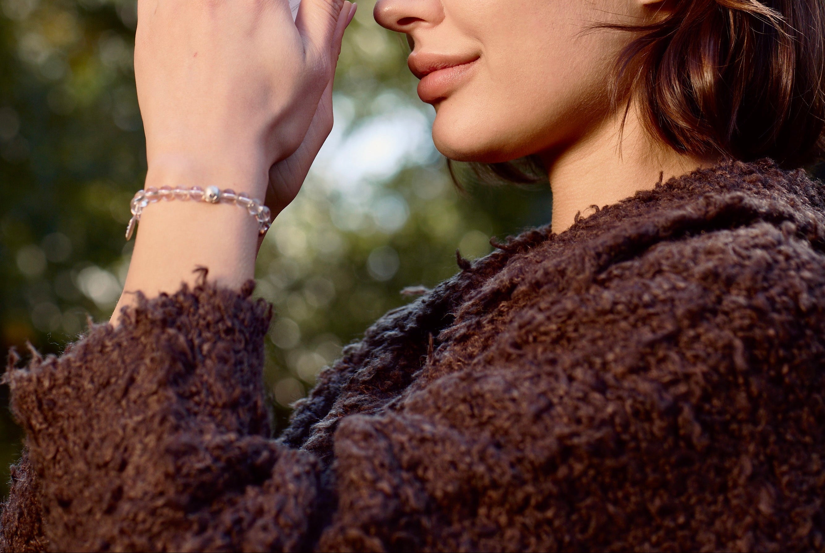 Woman wearing a crystal bracelet near her face